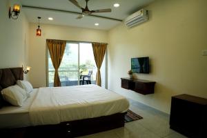 a bedroom with a bed and a television and a balcony at Hotel green hills in Waki