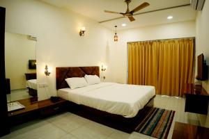 a bedroom with a bed and a ceiling fan at Hotel green hills in Waki