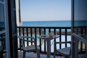 a table and chairs on a balcony with the ocean at Remezzo Guesthouse in Agios Ioannis Pelio