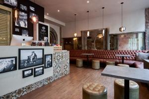 a restaurant with a bar with a red leather couch at Hotel GIO in Munich