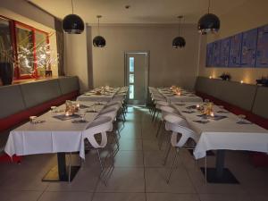 a row of tables in a restaurant with white table linen at Hotel Galaxie in Zlín +42 photos