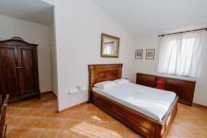 a bedroom with a bed and wooden furniture and a window at Gli olivi in Formello