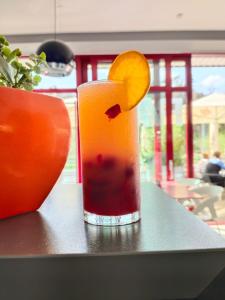 a drink sitting on a table with an orange slice at Hotel Galaxie in Zlín