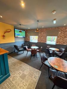 a restaurant with tables and chairs and a tv at The Victoria Bar & Hotel in Wakefield