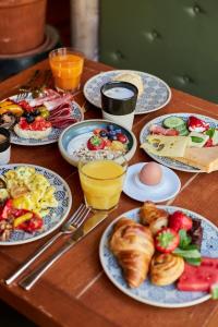 a wooden table with plates of breakfast foods and drinks at Hotel GIO in Munich