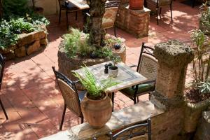 a table with chairs and a table with a plant on it at Hotel GIO in Munich