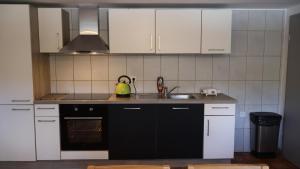 a kitchen with white cabinets and a sink at Haus Wangen in Dürler