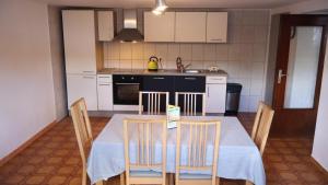 a kitchen with a table with chairs and a kitchen with white cabinets at Haus Wangen in Dürler +6 photos