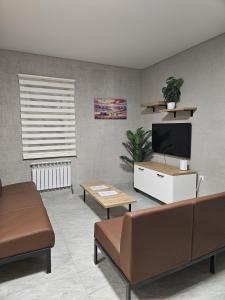a living room with a couch and a flat screen tv at Qonaq Hostel in Astana