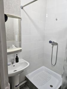 a white bathroom with a sink and a shower at Qonaq Hostel in Astana +8 photos