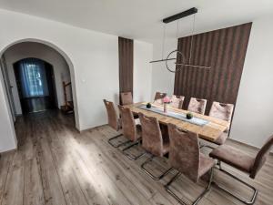 a dining room with a wooden table and chairs at Beta Apartman in Bük