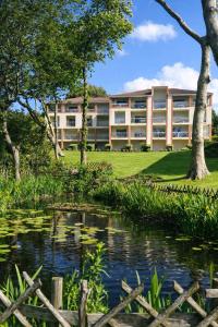 an apartment building with a pond in front of it at Le VALLON à POR-NIC in Pornic