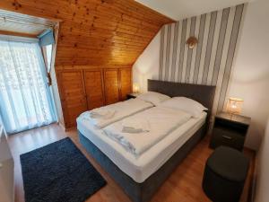 a bedroom with a large bed with a wooden ceiling at Beta Apartman in Bük