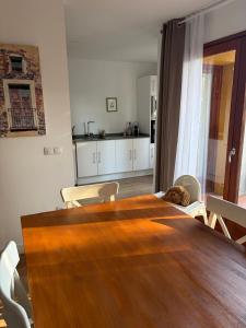 ein Esszimmer mit einem Holztisch und eine Küche in der Unterkunft Com a casa in Falset