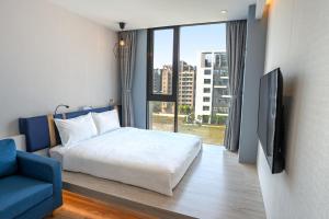 a bedroom with a bed and a tv and a couch at Explore Hotel in Taichung