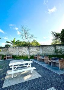 a white picnic table and benches in front of a brick wall at AAvista in Basbas