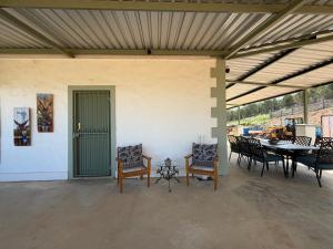 a covered patio with chairs and a table and a tableablish at Windkraal Farm Studio in Bonnievale +22 photos