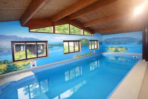 a swimming pool in a house with a painting on the wall at Neaum Crag Lodge ideal for a couple or family with young children in a woodland setting at Skelwith Bridge in Grasmere