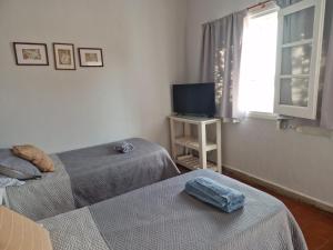a room with two beds and a tv and a window at Alojamiento La Liboria, solo mujeres in Córdoba