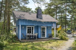 a blue house with a table in front of it at Ferienhaus Seestern - Bade- & Saunawelt täglich inklusive in Baabe
