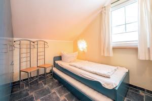 a small bedroom with a bed and a window at Ferienhaus Seestern - Bade- & Saunawelt täglich inklusive in Baabe +15 photos