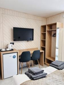 a room with a table and two chairs and a tv at Old Friend Guest House in Berehove