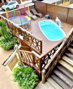 an outdoor pool with a wooden deck with a jacuzzi tub at Pousada Vila do Cowboy in Penha