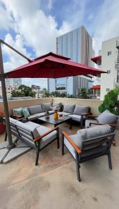 a patio with a red umbrella and a table and chairs at Ankara Residence in Santo Domingo