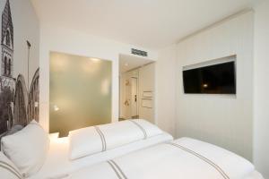 a white room with a bed and a tv at Premier Inn Freiburg City Nord in Freiburg im Breisgau +24 photos