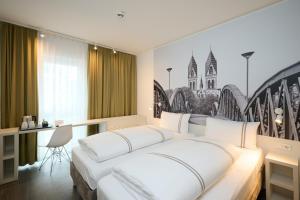 a bedroom with a large white bed and a desk at Premier Inn Freiburg City Nord in Freiburg im Breisgau