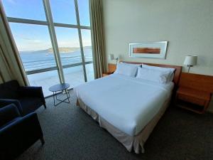 a hotel room with a bed and a large window at Novotel Puerto Montt in Puerto Montt +37 photos