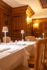 a dining room with white tables and chairs at Hotel Alaska Cortina in Cortina dʼAmpezzo