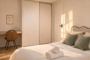 a bedroom with a bed with two towels on it at Immeuble privatif 3 logements et 1 logement non loin de l'immeuble in Le Portel