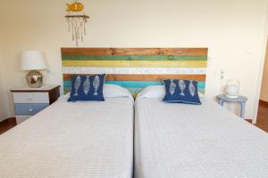 two beds in a bedroom with blue pillows at Terraza al Mar La Fosca in Palamós +10 photos