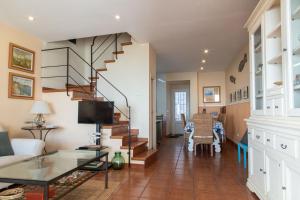 a living room with a spiral staircase and a table at Terraza al Mar La Fosca in Palamós