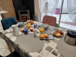 a table with breakfast foods on it with a fireplace at chambre d 'hôtes les Orchidées in Perpignan