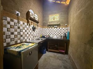 a small kitchen with a sink and a refrigerator at The Mud House in Talalla South