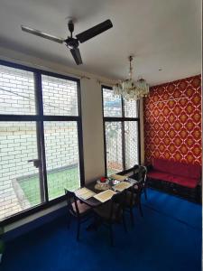 a dining room with a table and chairs and windows at hotel tripta ganga in Rishīkesh
