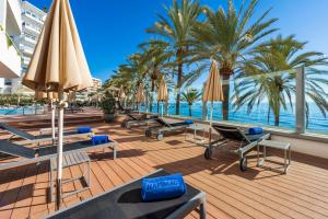 a deck with chairs and umbrellas and the ocean at Hapimag Apartments Marbella in Marbella