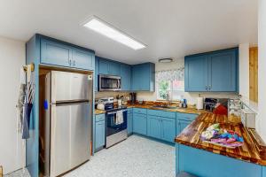a kitchen with blue cabinets and a white refrigerator at Mountain-View Patio, 1 Mi From UO Campus in Eugene
