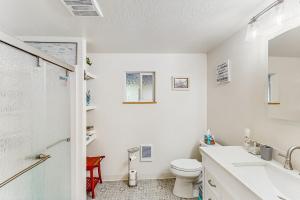 a white bathroom with a toilet and a sink at Mountain-View Patio, 1 Mi From UO Campus in Eugene +16 photos