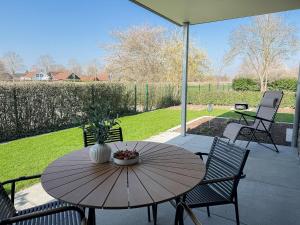 a wooden table and chairs on a patio at Ferienwohnung Gartenidyll am Dümmer See in Lembruch