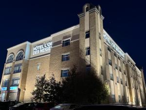 a large building with a sign on the side of it at Hotel L'Oie des neiges in Lévis