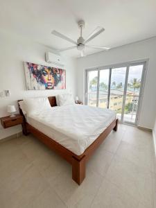 a bedroom with a large bed with a ceiling fan at Mananero III in Sosúa +63 photos