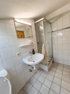 a white bathroom with a sink and a shower at Sonnenblumen in Hörbranz