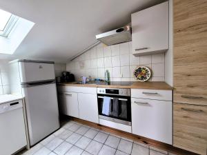 a small kitchen with white appliances and a sink at Sonnenblumen in Hörbranz