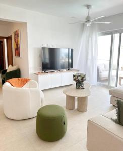 a living room with a tv and a couch and a table at Mananero III in Sosúa