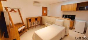 a small room with a bed and a kitchen at Starlis Home - Versátil in Cuiabá