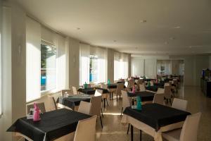 ein Esszimmer mit Tischen und Stühlen, die mit rosa Servietten bedeckt sind in der Unterkunft Hotel Angelini in Nago-Torbole
