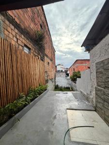 a courtyard with a wooden fence and plants at Casinha Verde, Itacaré in Itacaré